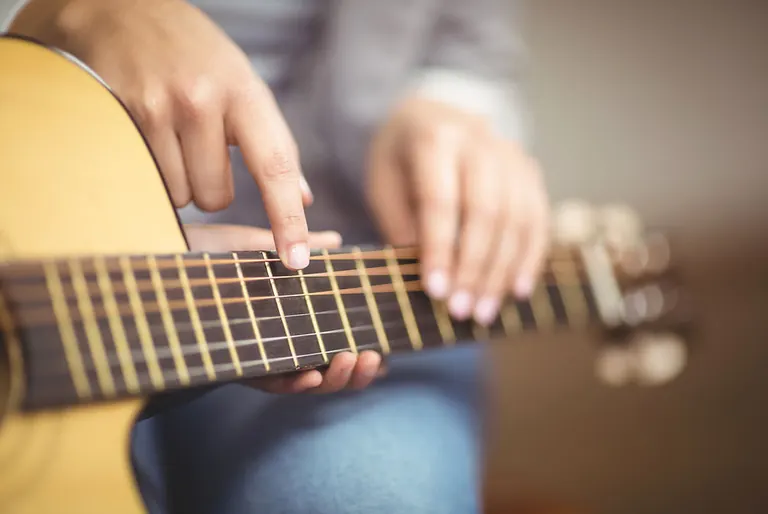 Playing acoustic guitar for guitar lessons