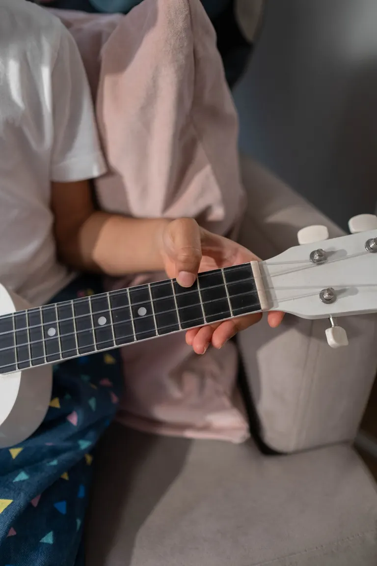 Close-up of a child playing ukulele